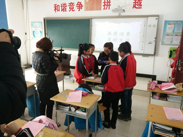 工作人员指导孩子如何鉴别过期食品_副本.jpg